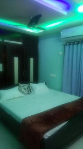 Cette chambre dispose d'un lit avec des lumières vertes et violettes. dans l'établissement gratifiedhomestay, à Visakhapatnam