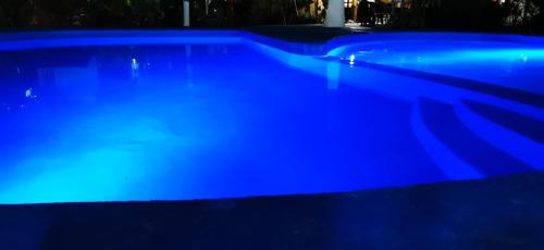 a large blue swimming pool at night at Hotel Oasis Melaque in San Patricio Melaque