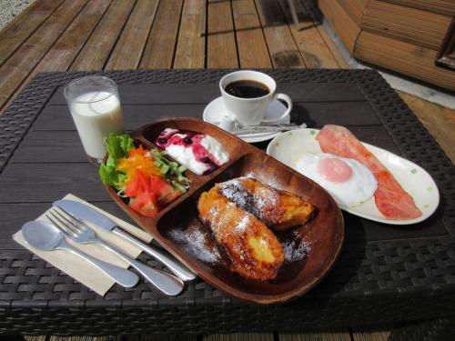a tray of breakfast food on a table with a glass of milk at DogrunCafe & Resorts JENNIE West-Karuizawa in Miyota