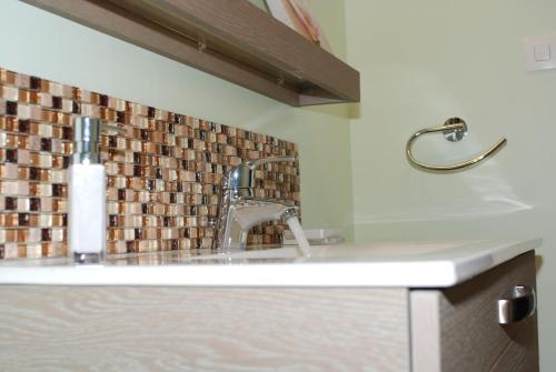 a sink in a bathroom with a tile back splash at myappartepinalF1 in Épinal