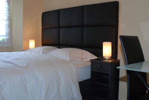 a bedroom with a large bed and a lamp on a night stand at myappartepinalF1 in Épinal