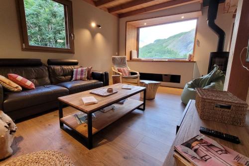 uma sala de estar com um sofá e uma mesa em Chalet l'ecrin - 6 pers with panoramic view of the Meije em La Grave