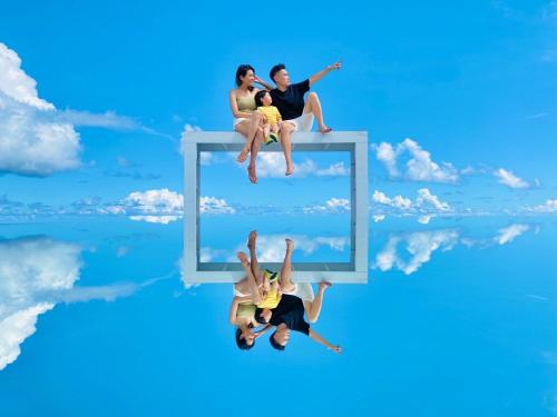 three people are sitting on a mirror in the sky at 太魯閣惠宇民宿 in Xincheng
