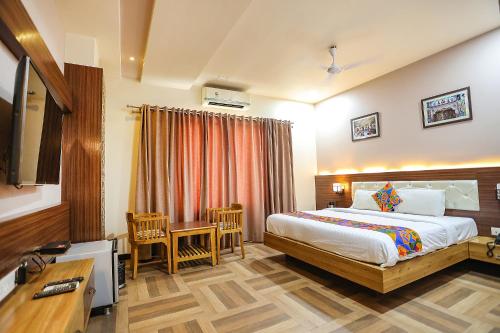 a bedroom with a bed and a desk and a television at Royal GM Plaza in Jaipur