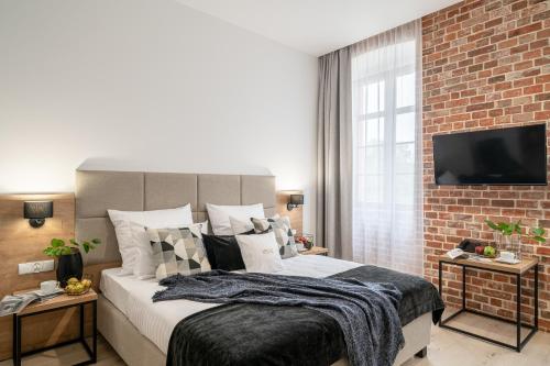 a bedroom with a large bed and a brick wall at Hotel Jazz Market Square Wroclaw in Wrocław