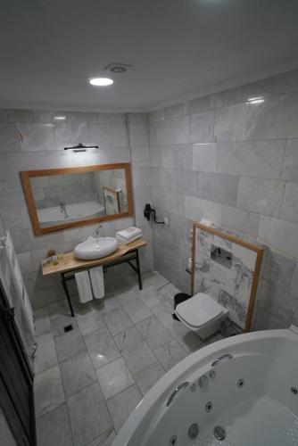 y baño con bañera, lavabo y espejo. en Vinum Bağ Oteli & Spa Tennis Courts By Edrine Vine en Edirne