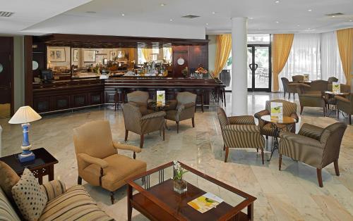 a lobby with chairs and tables and a bar at Hipotels Sherry Park in Jerez de la Frontera