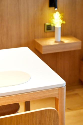 a white table with a vase of flowers on a counter at Lotte Buyeo Resort in Buyeo