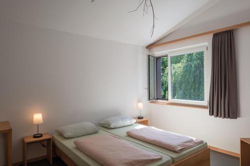 シュタイン・アム・ラインにあるStein am Rhein Youth Hostelのベッドルーム1室(ベッド2台、窓付)