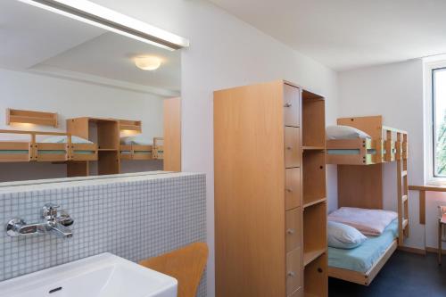 a bathroom with a sink and bunk beds at Stein am Rhein Youth Hostel in Stein am Rhein