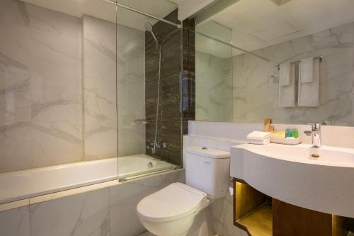 y baño con aseo, lavabo y ducha. en Sahid Raya Hotel & Convention Yogyakarta en Yogyakarta