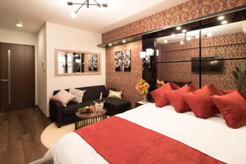 大阪市にある@RLiS_house大阪ドームシティの大きなベッド(赤い枕付)が備わる客室です。