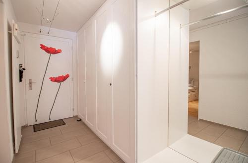a hallway with two red flowers on the wall at Rothornblick 04 by Arosa Holiday in Arosa