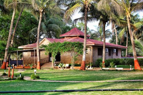 dom z palmami przed nim w obiekcie Stay Guru Resort Farm Villa w mieście Bhuj