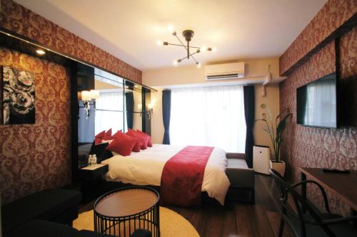 a bedroom with a large bed with red pillows at @RLiS_house大阪ドームシティ in Osaka