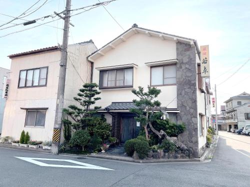 a building on a city street with a street at Business Ryokan Wakakusa in Tsu