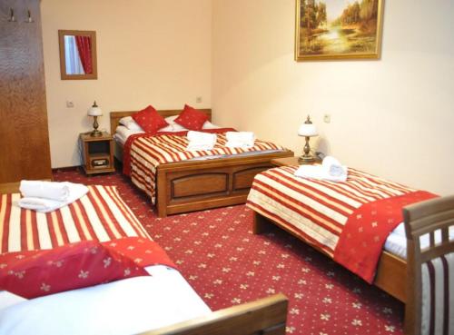 a hotel room with three beds in a room at Pensjonat Zbójecki Dwór - ATRAKCYJNY PAKIET ŚWIĄTECZNY - blisko basenów termalnych i szlaków górskich in Bukowina Tatrzańska