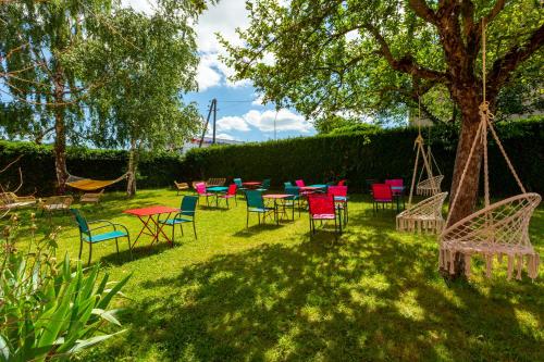un groupe de chaises et de tables sous un arbre dans l'établissement Deltour Hotel Le Puy En Velay, au Puy-en-Velay