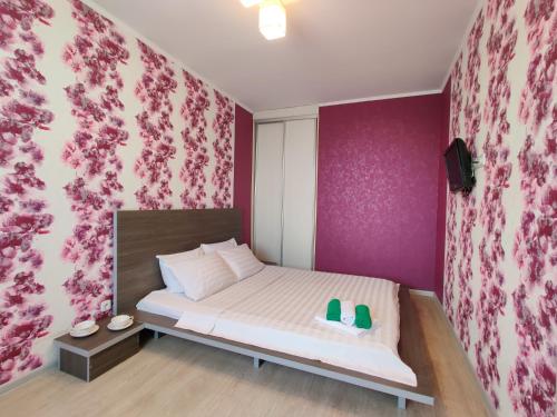 a bedroom with a bed with a pink wall at Apartment on Internacionalnaya 34 in Bobruisk