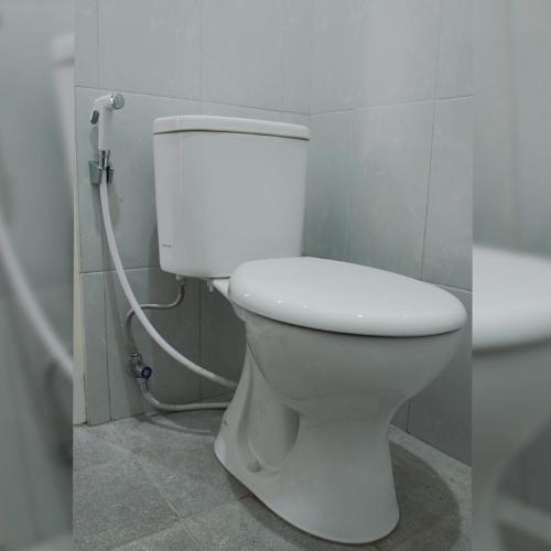 a bathroom with a white toilet in a room at Djuragan Kamar Kayon in Yogyakarta