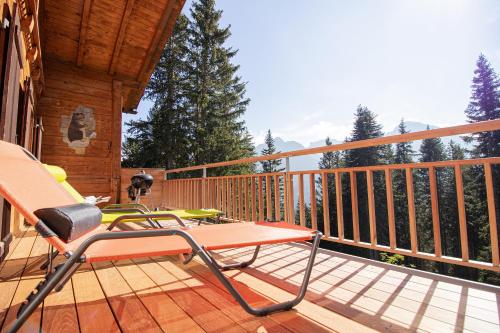 a deck with a table and a chair on a house at Chalet Soldanella by Arosa Holiday in Arosa