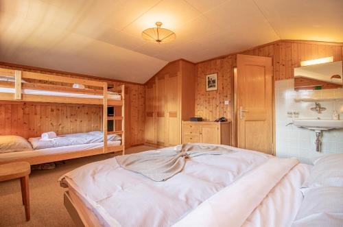 a bedroom with two bunk beds and a sink at Chalet Soldanella by Arosa Holiday in Arosa