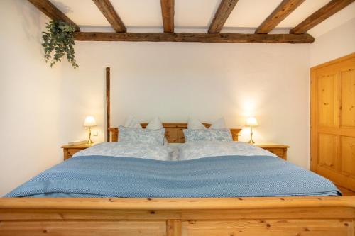 a bedroom with a wooden bed with blue sheets at Historic Lakeview Apartments Hallstatt in Hallstatt