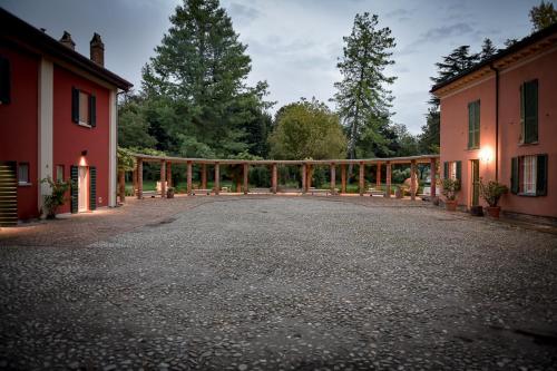 a driveway with a wooden fence next to two buildings at Tenuta Pizzone Wine Resort in Rivanazzano