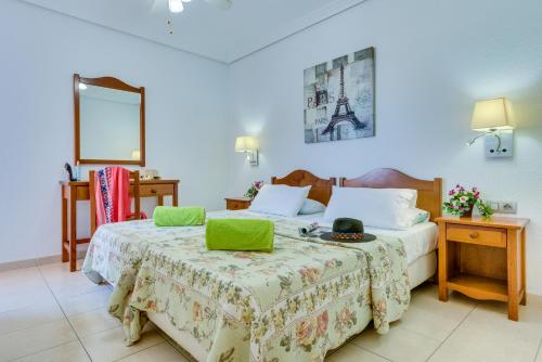 a bedroom with a bed with a green laptop on it at Tenerife South Apartments in Playa de las Americas