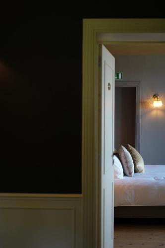 a bedroom with a bed with white sheets and pillows at Les Terrasses des Falizes B&B in Rochefort