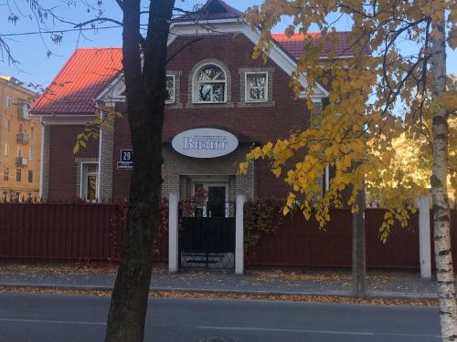 a red brick house with a sign on it at Hotel Vizit in Cherepovets