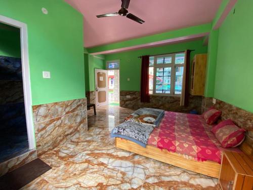 a bedroom with a large bed with green walls at Dream Valley Home Stay in Kasol