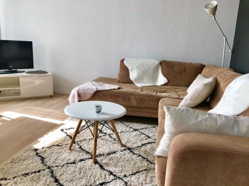 a living room with a couch and a table at Gemütliches Bergappartement mit Weitblick in Bad Bentheim