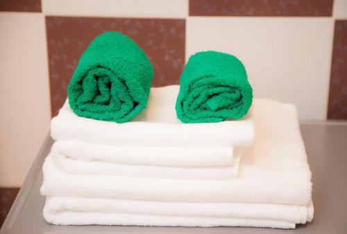 a stack of towels with green towels at Apartament on Gorkogo 26 in Bobruisk