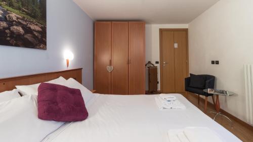 sypialnia z łóżkiem z fioletową poduszką w obiekcie Residence Pizzo Scalino w mieście Chiesa in Valmalenco
