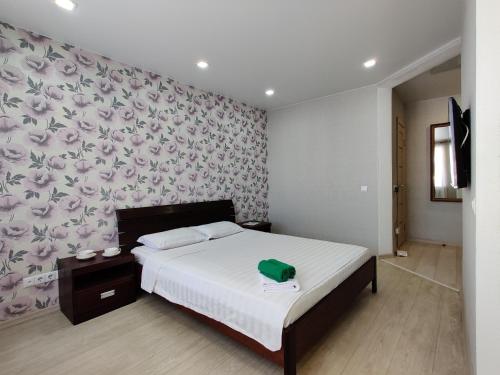 a bedroom with a bed with a flower patterned wall at Apartament on Oktyabrskaya 132 in Bobruisk