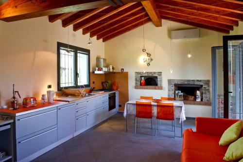 a kitchen with white cabinets and a table with red chairs at Caise in Castelnuovo Magra