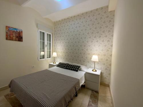 マドリードにあるEl Jardin del Angel Olmoのベッドルーム1室(ベッド1台、テーブルにランプ2つ付)