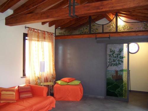 a living room with an orange couch and a window at Caise in Castelnuovo Magra