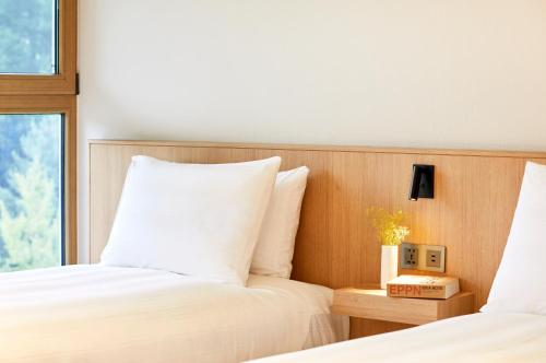 a bedroom with two beds and a window at Lotte Buyeo Resort in Buyeo