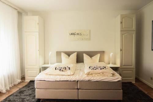 a bedroom with a bed with two pillows on it at Pesel im Friesenhaus Sieben-Linden ebenerdig in Archsum