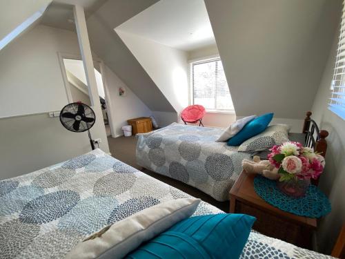 a bedroom with two beds and a table with flowers at The Chalet in Kew