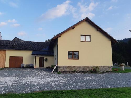 a house with a gravel driveway in front of it at Apartmány u Mlýna in Velké Losiny