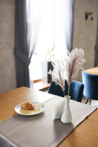 a table with a plate of food and a vase of flowers at SPA-Hotel Dodo in Zhytomyr
