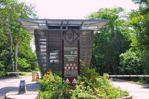 a sign in the middle of a garden with flowers at Manzini Chalets in St Lucia