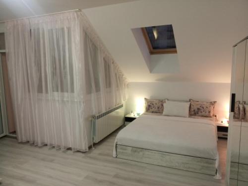 um quarto com uma cama branca e uma janela em IGLIKA 2 SNOWY NIGHT V 31 em Borovets