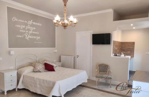 a bedroom with a bed and a chandelier at Chez Tata' - Scé Tatà in Rossano Stazione
