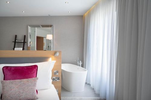 een slaapkamer met een bed, een wastafel en een spiegel bij The Morgan Hotel in Dublin