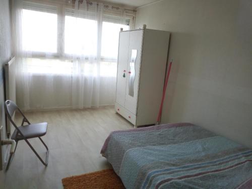 une chambre avec un lit, une commode et une fenêtre dans l'établissement Appartement lumineux proche de Rouen et Paris, à Saint-Étienne-du-Rouvray