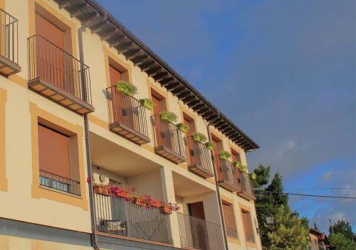 a building with balconies and potted plants on it at Apartamento Mirador del Pantano 1 in Vinuesa